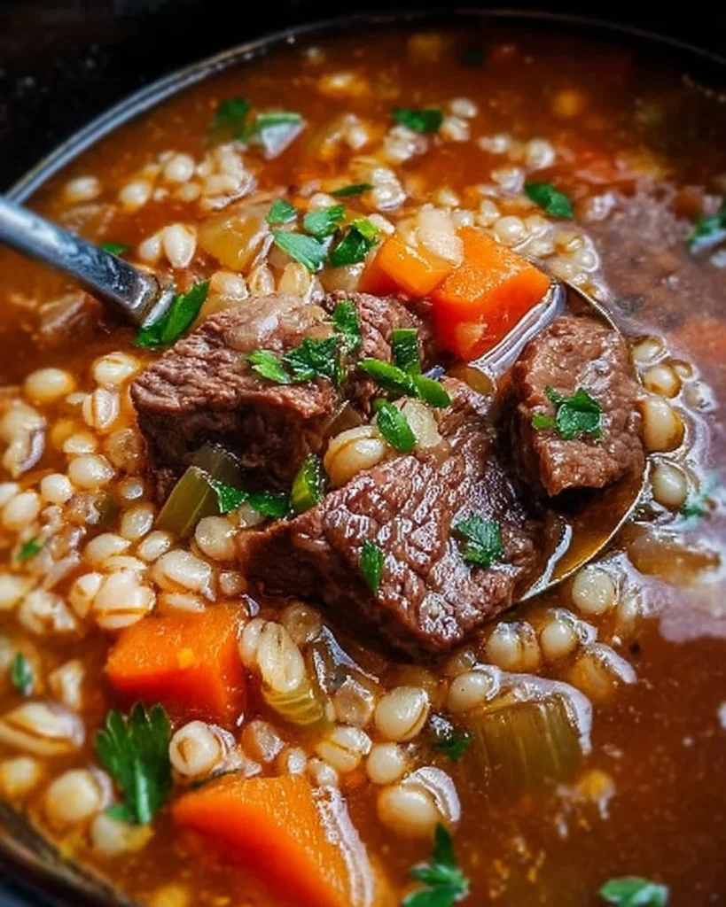Delicious Crockpot Beef and Barley Soup in a bowl with herbs on top