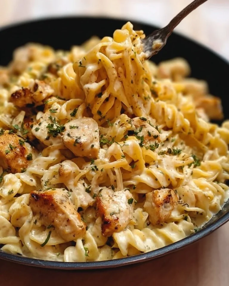 Creamy white cheddar chicken pasta served in a bowl with herbs