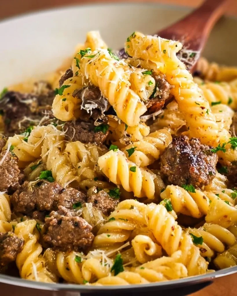 A bowl of Garlic Parmesan Beef Pasta with fresh parsley and grated cheese