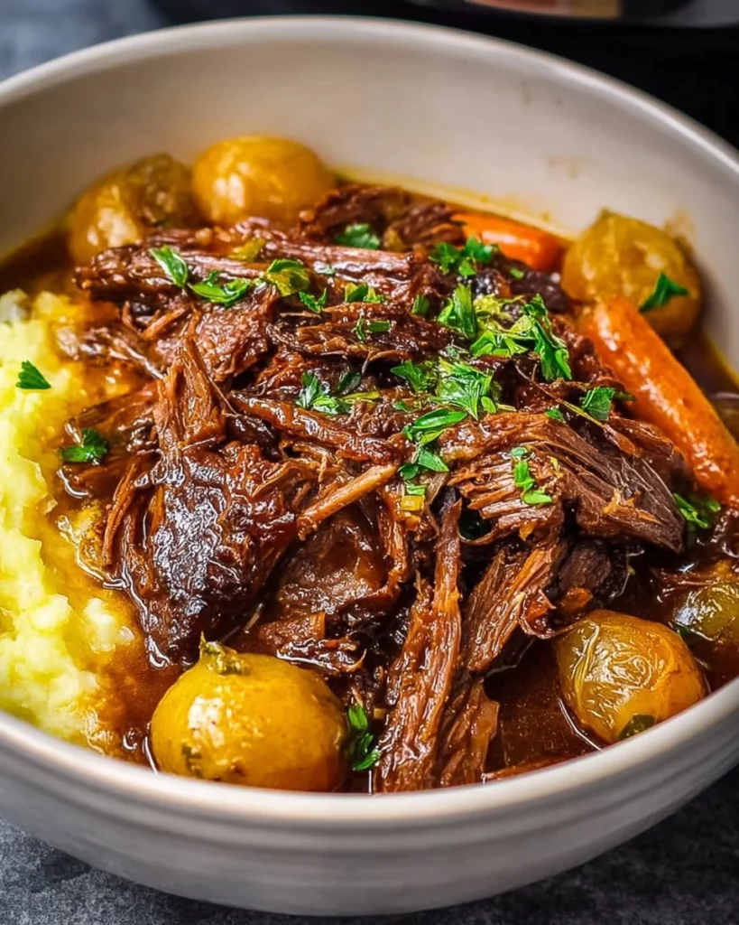 A tempting bowl of Slow Cooker Mississippi Pot Roast garnished with herbs.