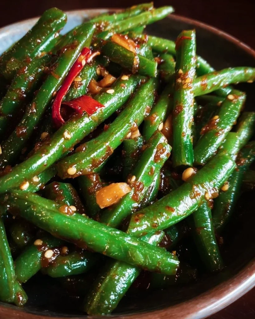 Plate of PF Chang's spicy green beans garnished with chili and garlic