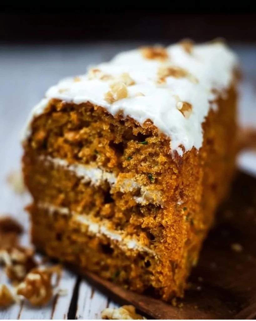 Deliciously moist Pumpkin Zucchini Cake topped with cream cheese frosting.