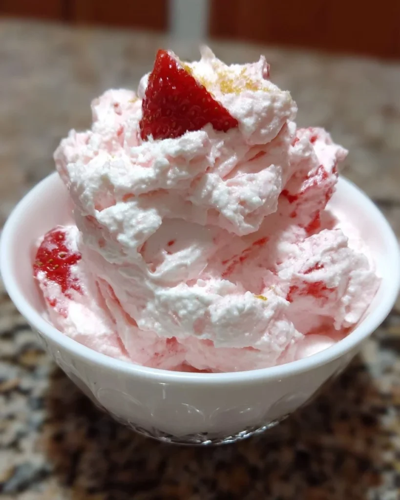 Delicious strawberry cheesecake fluff dessert topped with fresh strawberries.