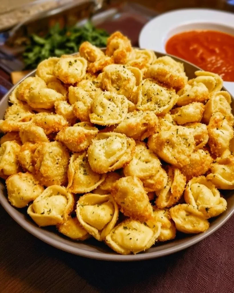 Cheese tortellini party snacks served on a platter with fresh herbs.