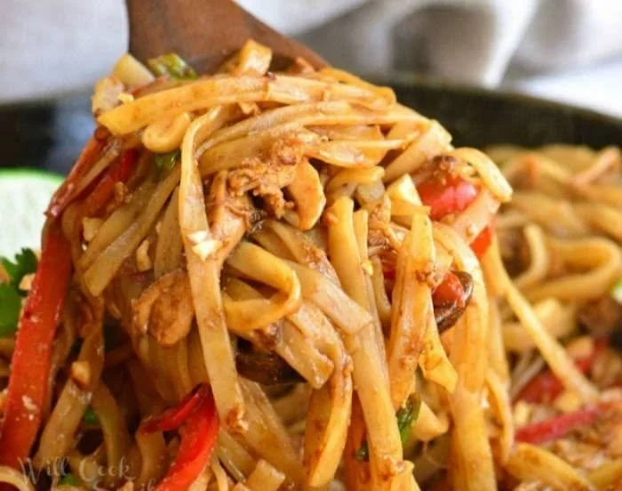 Delicious plate of Pad Thai garnished with lime and peanuts