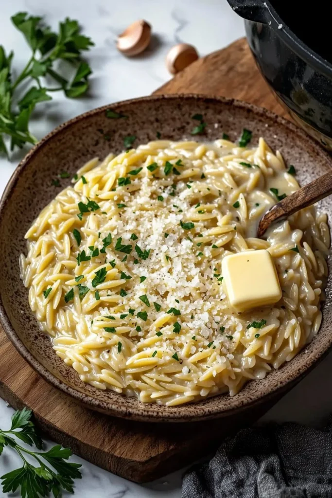 Creamy garlic parmesan orzo dish garnished with parsley and served in a bowl.