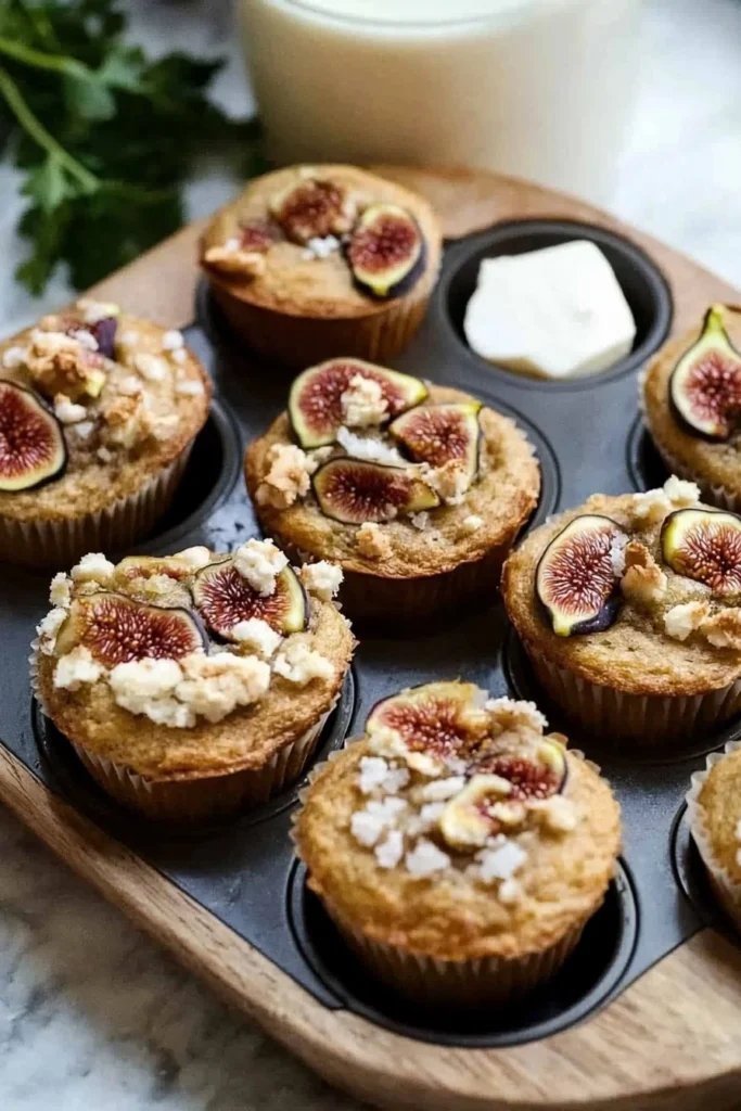 Freshly baked fig muffins ready to enjoy, topped with figs and nuts.