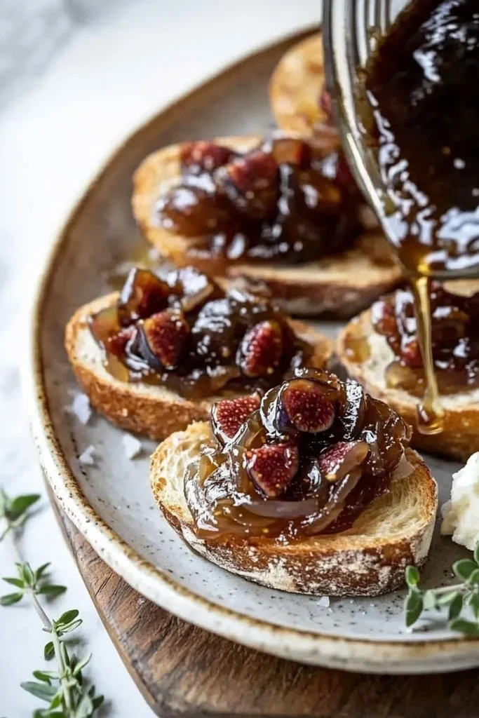 Onion and Fig Jam Crostini topped with fresh herbs
